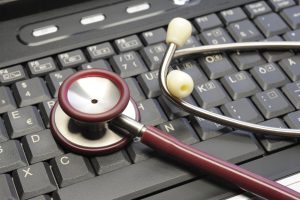Medical stethoscope on keyboard as symbol for administration and office